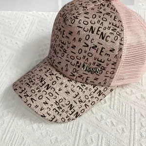 Detail of pink glitter baseball cap with graffiti letters and metal jeans badge