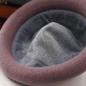 Detailed macro view showing the thick gray fleece lining and pink knit texture of the winter hat