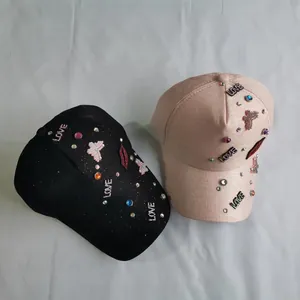 Detail of glitter baseball cap featuring colorful rhinestone LOVE and red lip embroidery