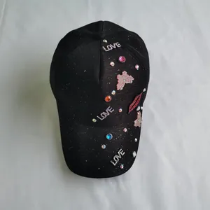 Detailed view of black baseball cap with rhinestone LOVE letters and sequin patches