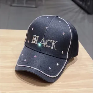 Dettaglio ravvicinato di strass luccicanti scritta 'BLACK' e cristalli su cappellino nero