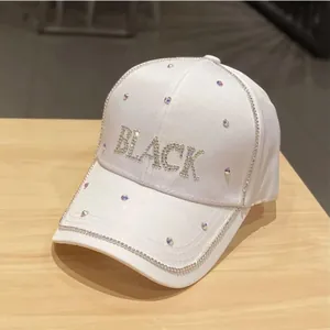 Dettaglio del cappellino da baseball in raso bianco con scritta BLACK in strass
