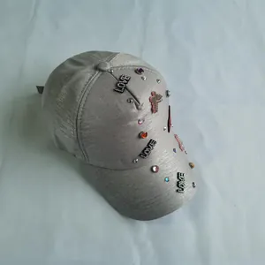Detailed view of silver glitter baseball cap with colorful rhinestones and LOVE pattern