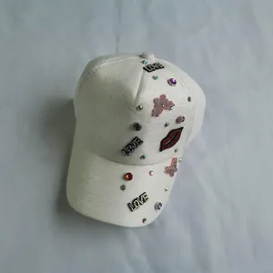 Detail of white baseball cap with rhinestone LOVE letters and red lip sequin patches