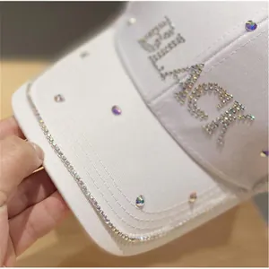 Dettaglio del berretto da baseball in cotone bianco con strass e la scritta BLACK