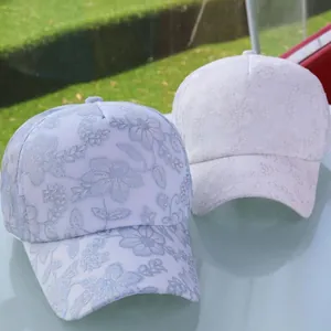 Détail de casquettes de baseball en dentelle bleue et blanche sur verre avec jardin