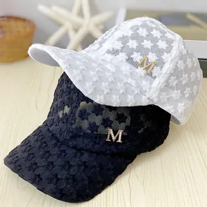 Detail view of summer lace baseball caps with floral patterns and M logo decoration