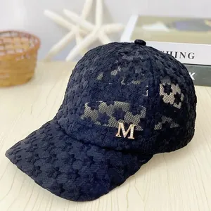 Detail of black summer lace baseball cap with floral embroidery and metallic M logo