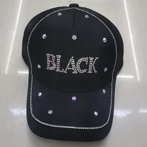 Dettaglio del cappello nero con lettere BLACK in strass e bordo di paillettes lucide