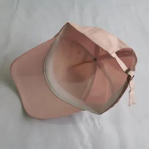 Detail view of pink baseball cap interior with sweatband and adjustable metal buckle