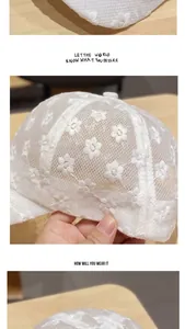 Close-up of white floral lace embroidery and breathable mesh texture on baseball cap