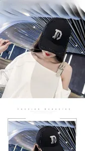 Detail der schwarzen Baseballkappe mit Strass-Buchstabe D und atmungsaktivem Mesh