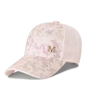 Detailed macro of pink baseball cap featuring camo sequins and golden M logo detail