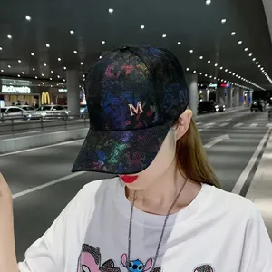 Detail of baseball cap with rhinestones M logo and sparkling texture in city street