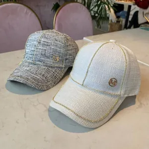 Chic tweed baseball caps in grey and cream with gold metal chain trim and M logo