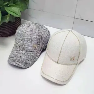 Fashionable tweed and cream baseball caps featuring metallic M logos and rhinestone trims