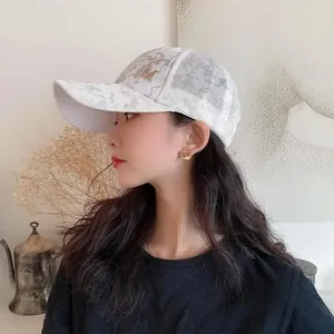 Side view of white camo mesh baseball cap with gold M logo on a female model