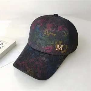 Detail of golden metal M logo and colorful abstract texture on the baseball cap side