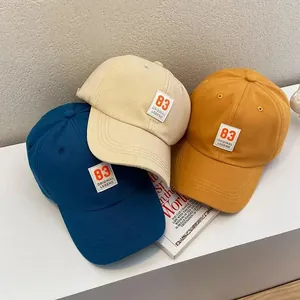 Three cotton baseball caps in blue, beige and yellow with retro number 83 patch