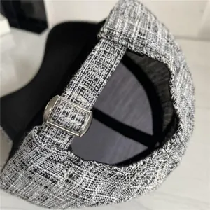 Detail view of tweed baseball cap back with adjustable silver metal buckle strap