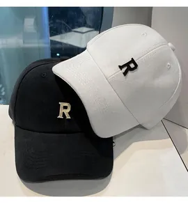 Détail du logo R brodé sur des casquettes de baseball en coton en noir et blanc