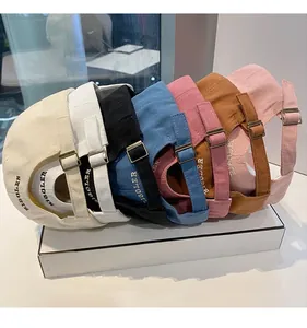 Détail de boucle métallique réglable et broderie Rigoler sur diverses casquettes en toile