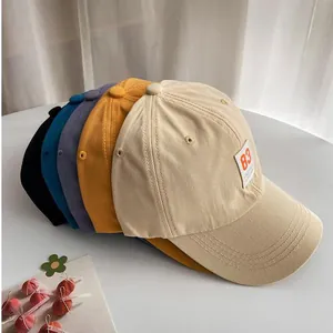 Stack of colorful cotton baseball caps with vintage 83 patch in various trendy colors
