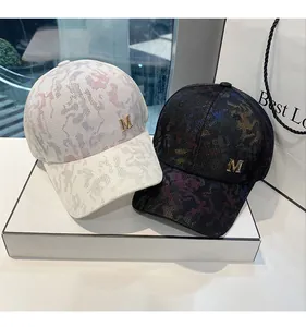 Detailed macro view of gold metal M logo on textured camouflage baseball cap