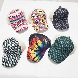 Detail showing six diverse printed trucker hats with mesh back and ponytail opening