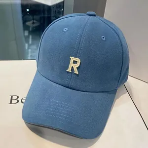Détail de la casquette de baseball en toile bleu marine avec lettre R brodée beige en 3D