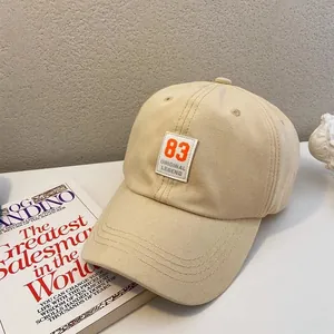 Detail of beige cotton baseball cap featuring number 83 patch and premium stitching