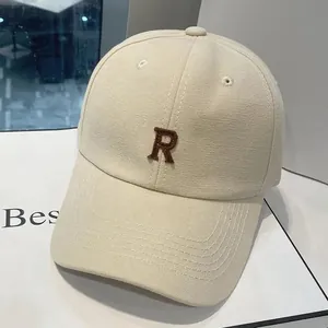 Gros plan d'une casquette en toile beige avec logo lettre R brodé en marron foncé