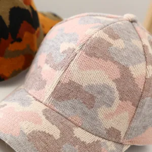 Macro shot of camouflaged pink knit baseball cap texture with detailed stitching