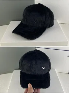 Détails d'une casquette de baseball noire en fausse fourrure avec logo M en métal argenté