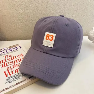Detail of a purple cotton baseball cap with orange number 83 patch in vintage style