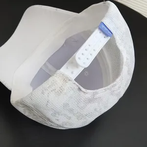 Detailed close-up of white baseball cap showing breathable mesh lining and adjustable strap