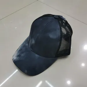 Dettaglio del cappellino tie-dye con rete nera traspirante e visiera curva sportiva