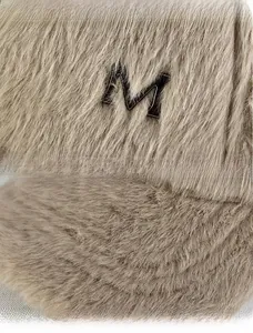 Détails de la texture en peluche et logo M métallique sur une casquette de baseball beige