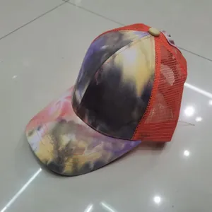Dettaglio del cappellino trucker tie-dye colorato con rete arancione traspirante e retro