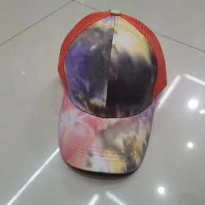Vista dall'alto del cappello trucker tie-dye con motivi vivaci e rete arancione traspirante