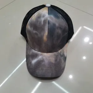 Dettaglio del cappello trucker con motivo tie-dye fumo e rete nera traspirante sul retro