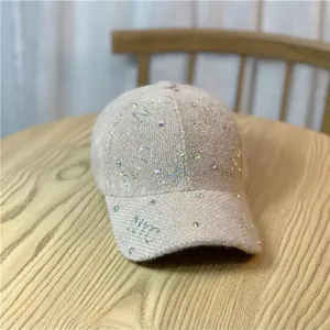 Detailed close-up of tweed winter baseball cap with NYC lettering and sparkling rhinestones