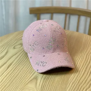 Detail of pink tweed baseball cap featuring shiny colorful rhinestone NYC letter pattern