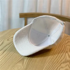 Detail of white textured fabric baseball cap with inner lining and metal buckle adjustment