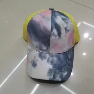 Vista dettagliata del motivo tie-dye e della rete gialla traspirante sul cappello trucker