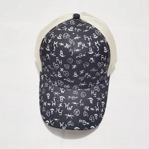 Detail view of graffiti print trucker hat with black fabric brim and cream mesh back