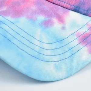 Dettaglio ravvicinato del motivo tie-dye e cuciture blu sulla visiera del cappello