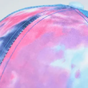 Dettaglio ravvicinato delle cuciture di un cappello tie-dye in tonalità rosa e viola