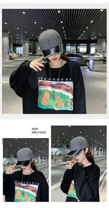 Détail de la casquette pied-de-poule avec visière en cuir noir et logo M brodé