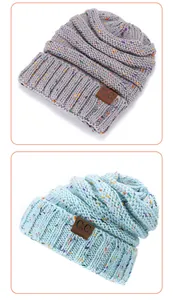 Detail of speckled knit beanie showing chunky texture and brown leather C.C logo patch